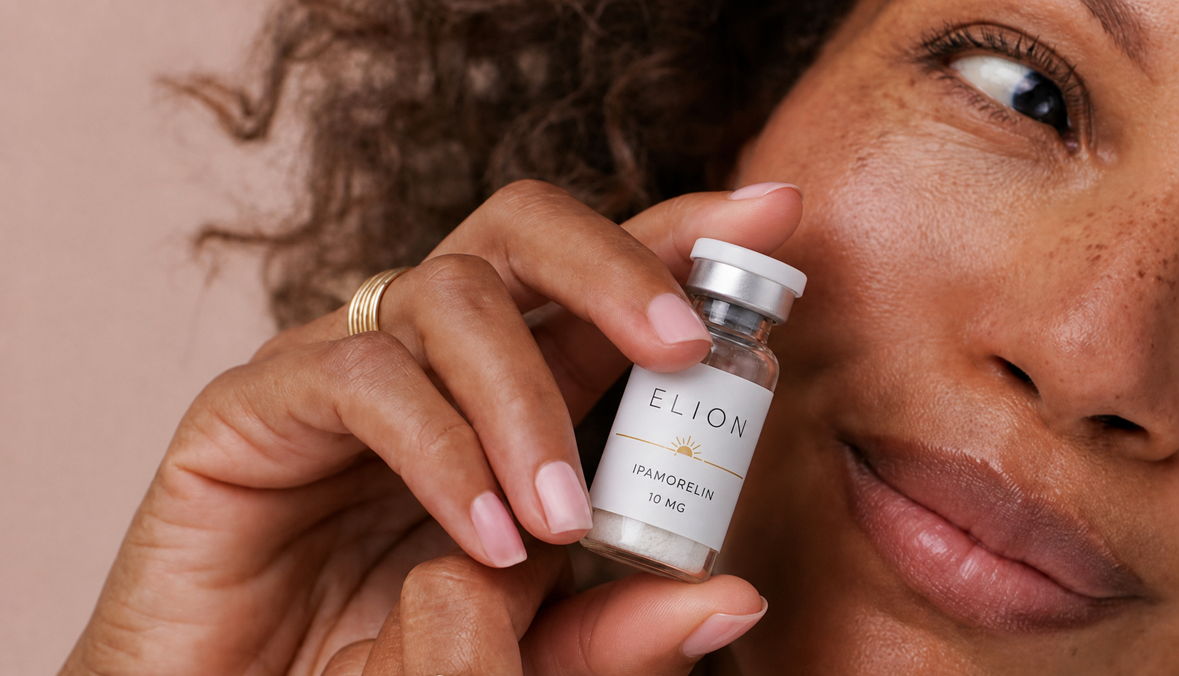 A woman holding a vial of Elion peptides.