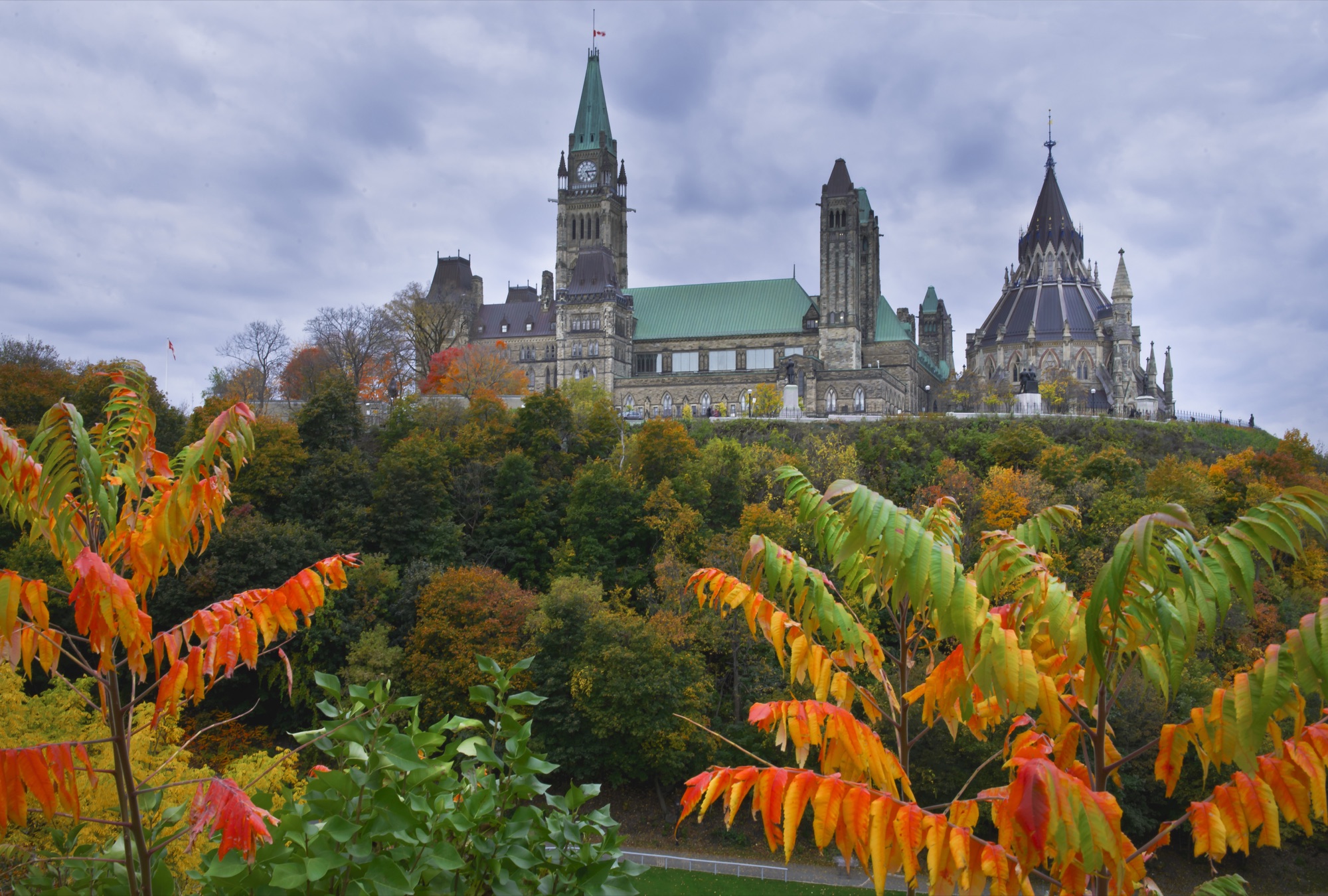 Parliament Hill's Centre Block and Library of Parliament framed by autumn foliage