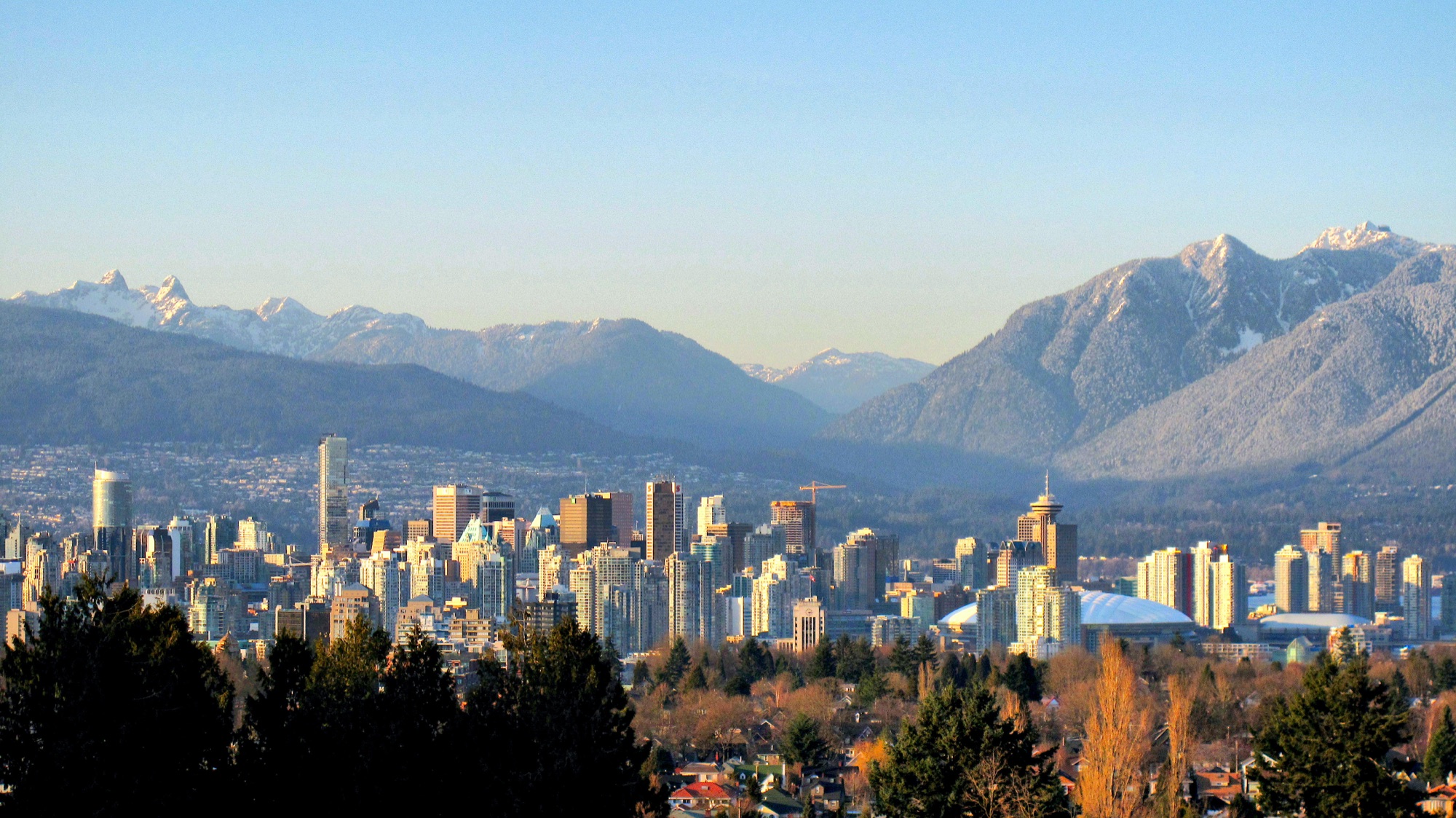Vancouver's downtown skyline at golden hour with the North Shore mountains behind it