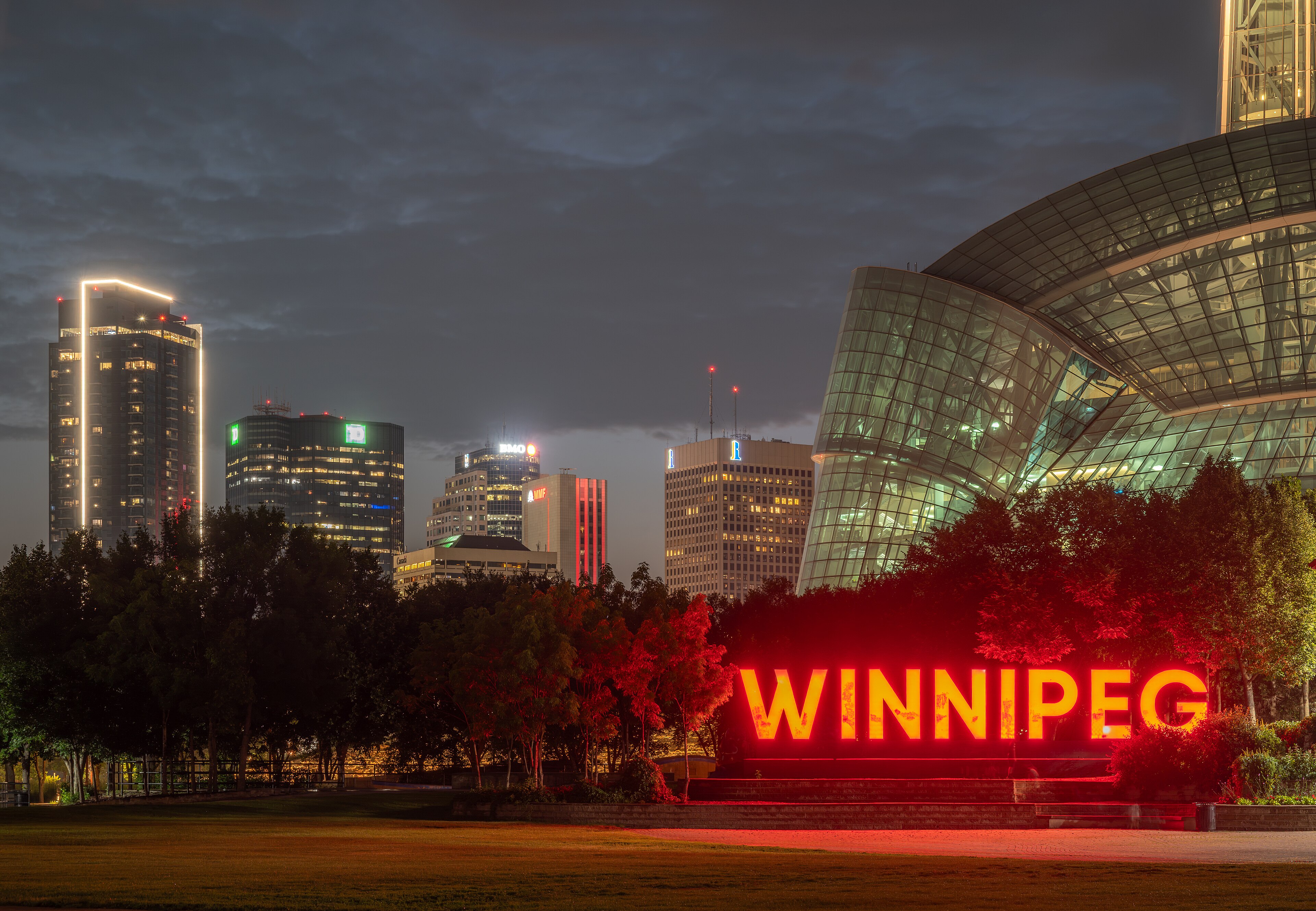 The illuminated Winnipeg sign at The Forks with the Canadian Museum for Human Rights and downtown skyline behind it